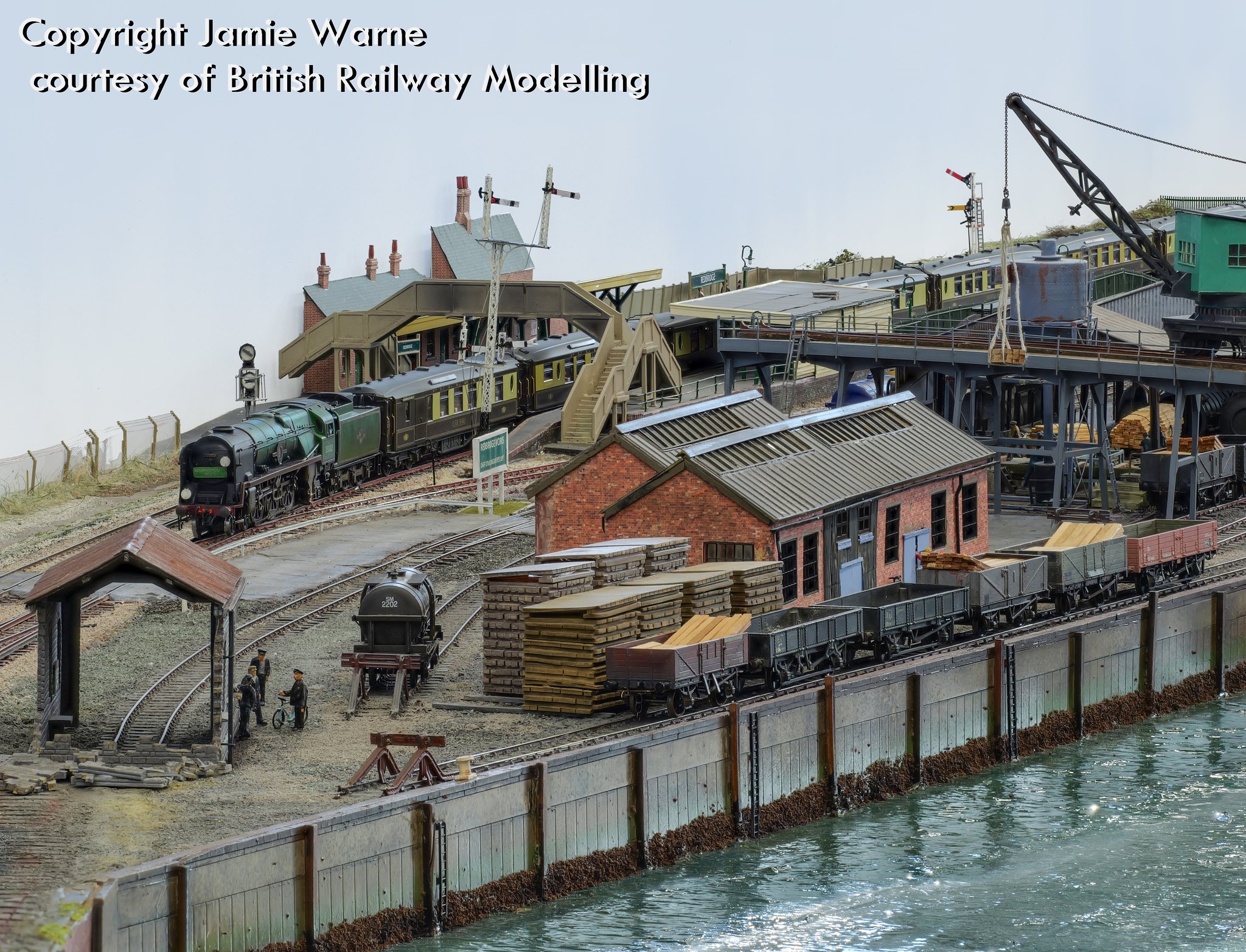 Steam train at Redbridge station above the sleeper works, crane and timber wharf