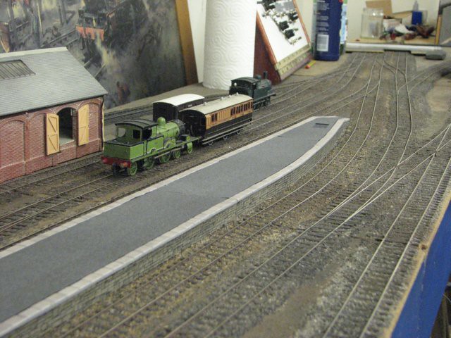 Tank engine with a short passenger train alongside the platform at Mawgan Porth