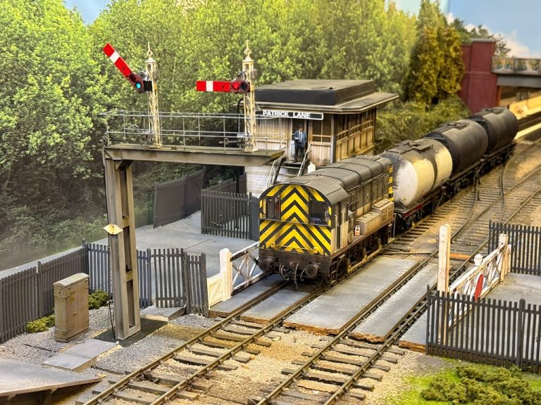 Class 08 shunter with tank wagons passing the signal gantry at Patrick Lane