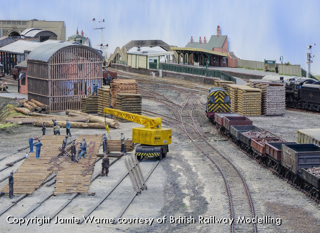 Gangers at work among timber stacks and a shunter in the Redbridge works yard