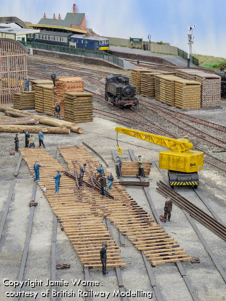 Platelayers assembling pointwork beside a yellow rail crane in the Redbridge yard