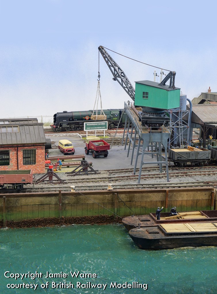 Steam crane on the Redbridge wharf with loaded barges moored alongside